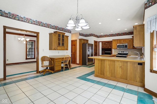 kitchen featuring a chandelier, decorative light fixtures, kitchen peninsula, sink, and appliances with stainless steel finishes