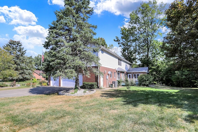 view of front of home with a front yard and a garage