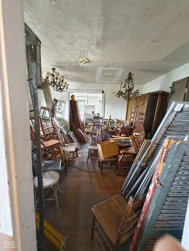 misc room featuring a notable chandelier, a textured ceiling, and hardwood / wood-style flooring