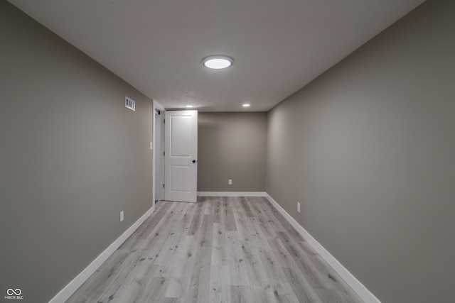 unfurnished room with visible vents, light wood-style floors, and baseboards