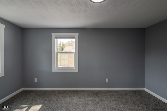 spare room featuring baseboards, carpet floors, and a textured ceiling