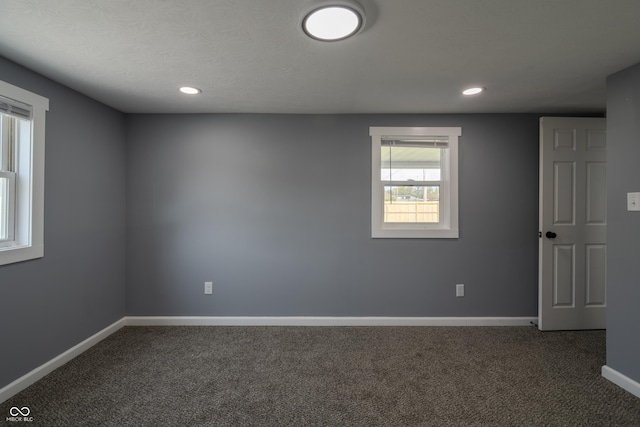 spare room featuring recessed lighting, baseboards, and dark carpet