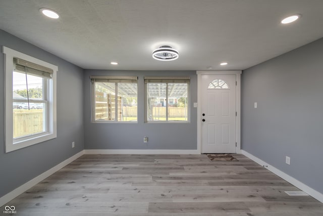 foyer with recessed lighting, wood finished floors, and baseboards