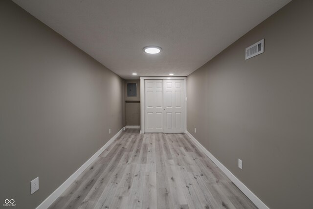 unfurnished bedroom featuring visible vents, baseboards, a closet, and light wood-style flooring