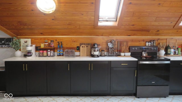 114 N Grant Ave, Crawfordsville, IN 47933 - kitchen featuring vaulted ceiling with skylight, light countertops, wooden walls, dark cabinetry, and electric stove