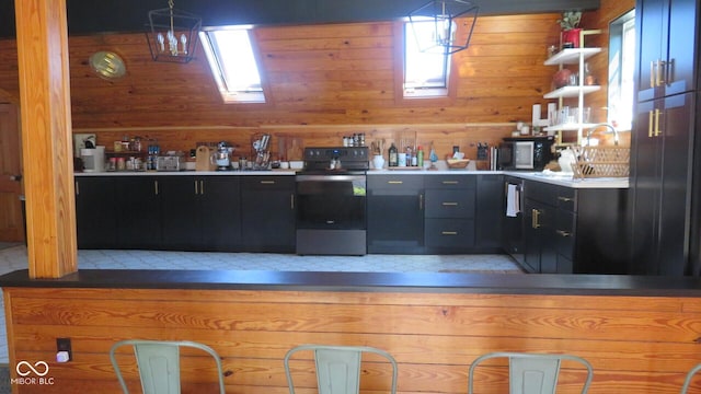 114 N Grant Ave, Crawfordsville, IN 47933 - kitchen featuring dark cabinetry, appliances with stainless steel finishes, wooden walls, and open shelves