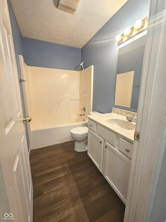 full bathroom with a textured ceiling, shower / tub combination, wood-type flooring, vanity, and toilet