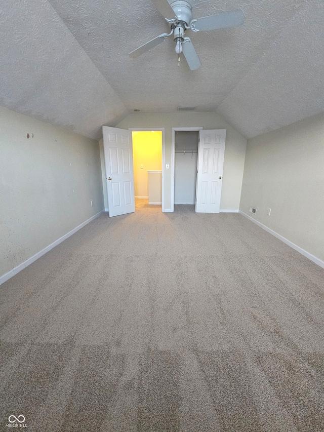 additional living space with ceiling fan, a textured ceiling, carpet, and vaulted ceiling