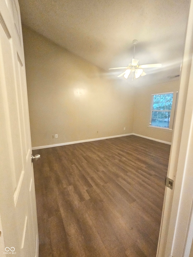 empty room with dark wood-type flooring and ceiling fan