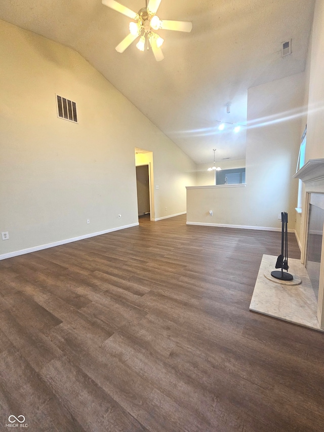 unfurnished living room with ceiling fan, high vaulted ceiling, and dark wood-type flooring