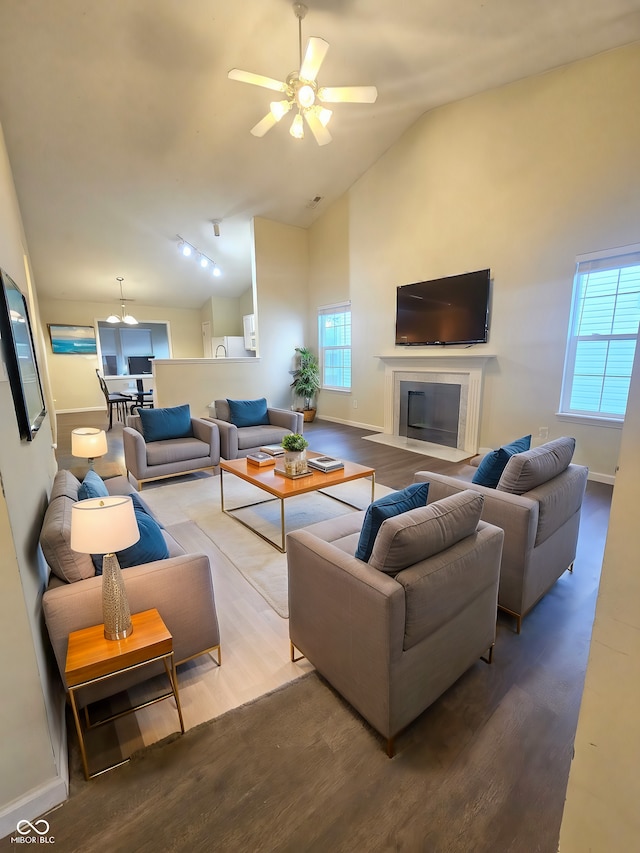 living room with hardwood / wood-style floors, vaulted ceiling, and ceiling fan