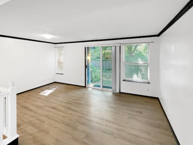 empty room with ornamental molding and light hardwood / wood-style floors