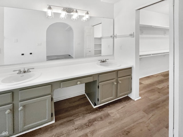 bathroom featuring double vanity, a sink, and wood finished floors
