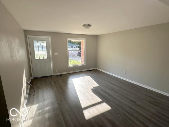 interior space featuring dark wood-type flooring and baseboards