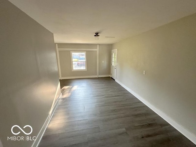 unfurnished room with dark wood finished floors and baseboards