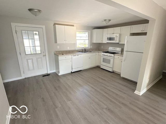 kitchen with a sink, white appliances, dark wood-style flooring, and white cabinetry