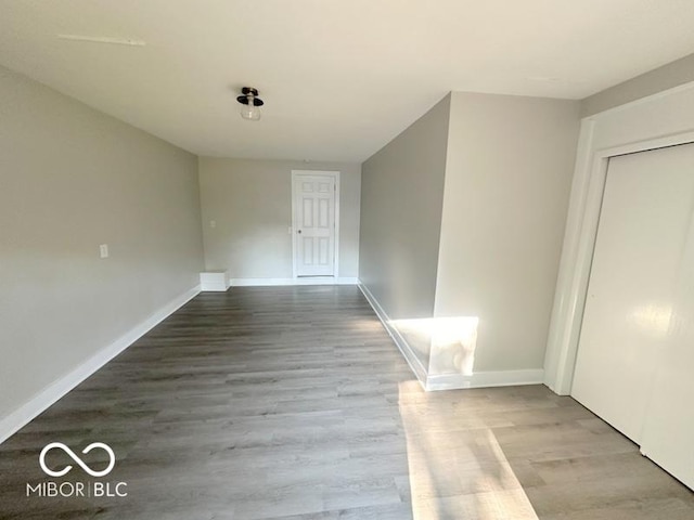 unfurnished room featuring baseboards and wood finished floors