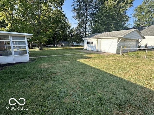 view of yard featuring a detached garage, an outdoor structure, and fence