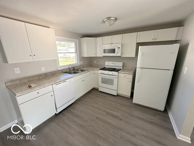 kitchen with a sink, white appliances, white cabinets, and dark wood finished floors