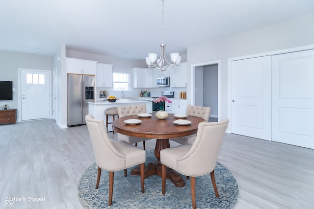 dining space featuring light hardwood / wood-style flooring and an inviting chandelier