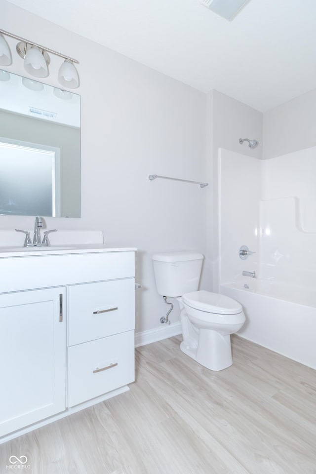 full bathroom with vanity, hardwood / wood-style flooring, toilet, and shower / bathtub combination