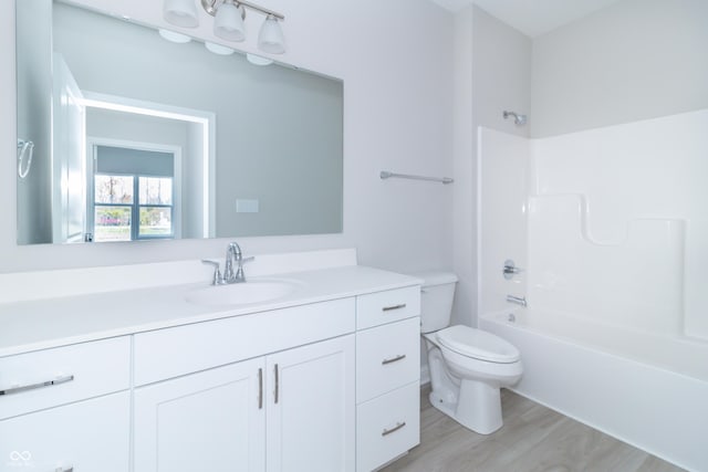 full bathroom with hardwood / wood-style floors, vanity, toilet, and shower / bathing tub combination