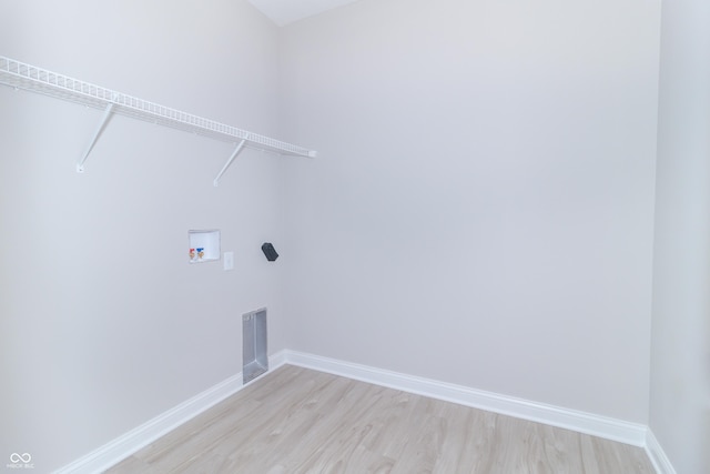 laundry area featuring washer hookup and light hardwood / wood-style floors