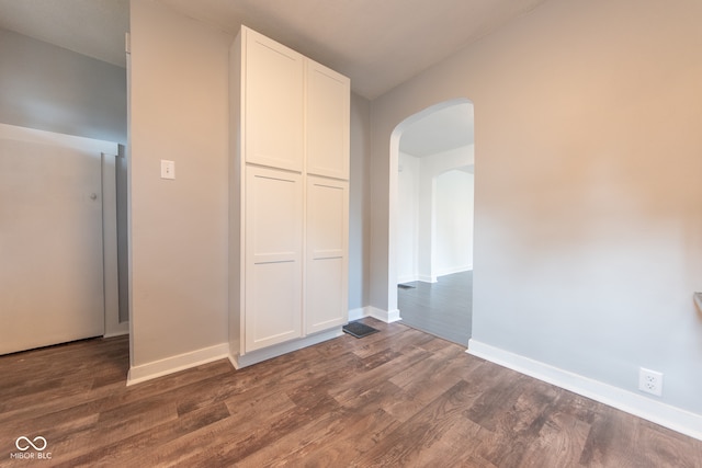 unfurnished bedroom with dark hardwood / wood-style floors and a closet