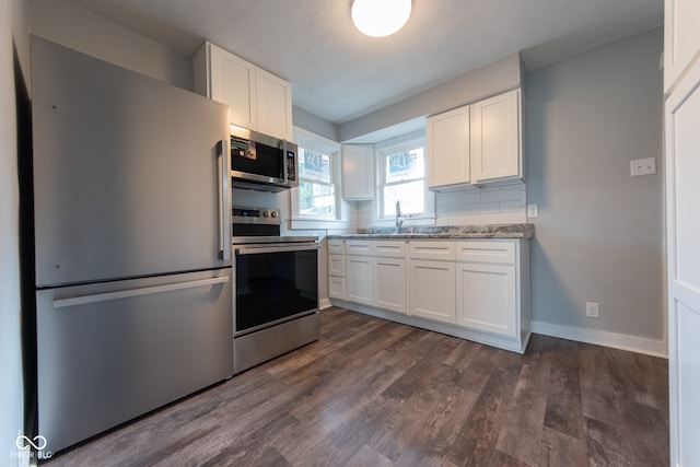 kitchen with sink, dark hardwood / wood-style flooring, white cabinets, and appliances with stainless steel finishes