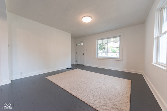 unfurnished room with dark hardwood / wood-style flooring