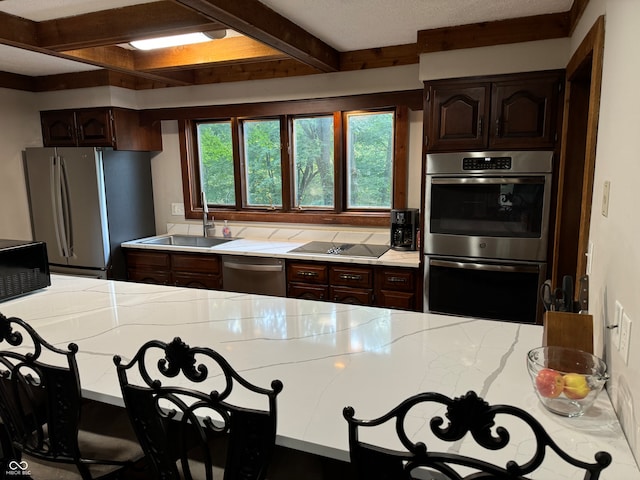 kitchen featuring dark brown cabinets, black appliances, sink, and beam ceiling