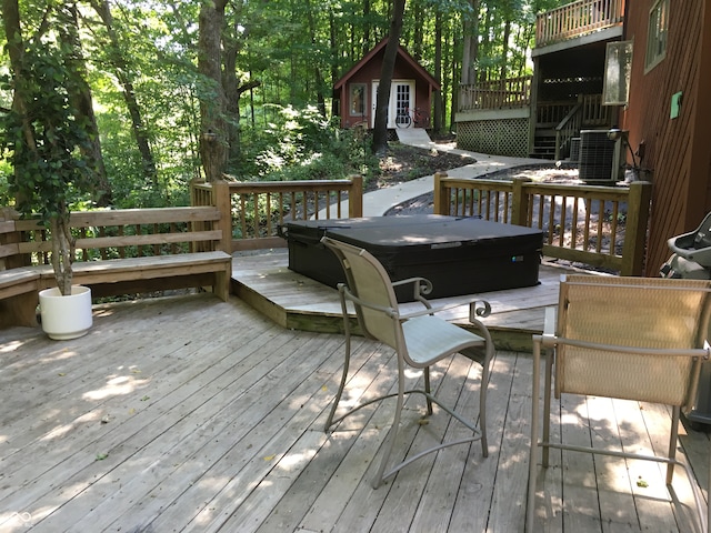 wooden deck featuring an outdoor structure and central AC unit