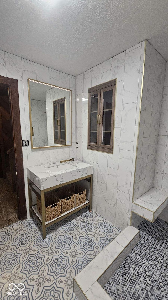 bathroom with tile walls, a textured ceiling, and vanity