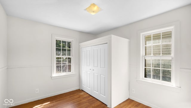 unfurnished bedroom featuring a closet and hardwood / wood-style flooring