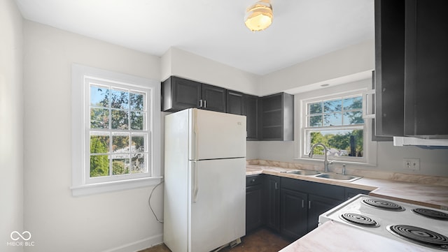 kitchen featuring white refrigerator, plenty of natural light, and sink