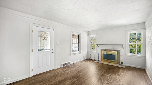 unfurnished living room featuring a textured ceiling and dark hardwood / wood-style floors