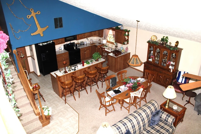 dining area with visible vents, lofted ceiling, and light carpet