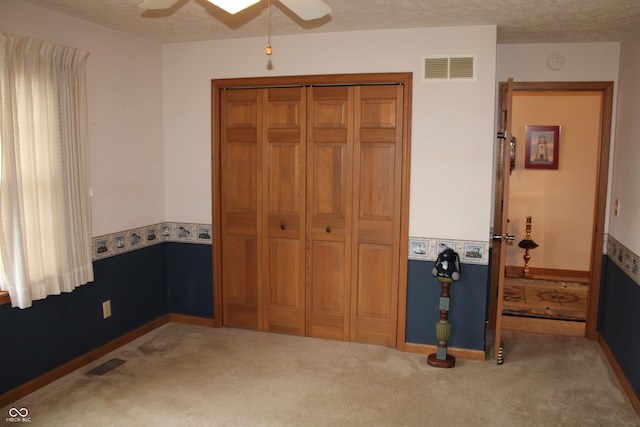 carpeted bedroom with visible vents, baseboards, and a textured ceiling