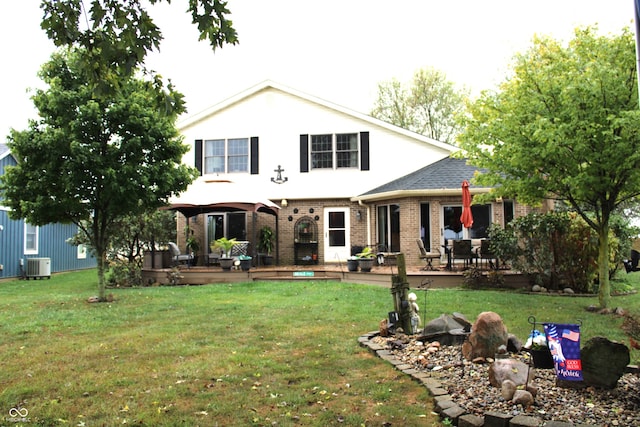 back of house featuring a deck, a yard, and central AC