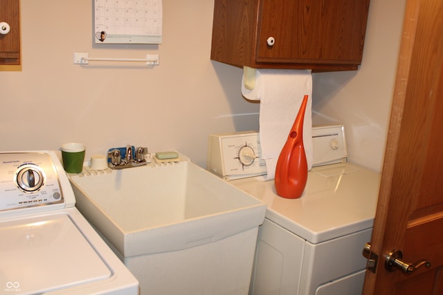 laundry room featuring washing machine and dryer, sink, and cabinets