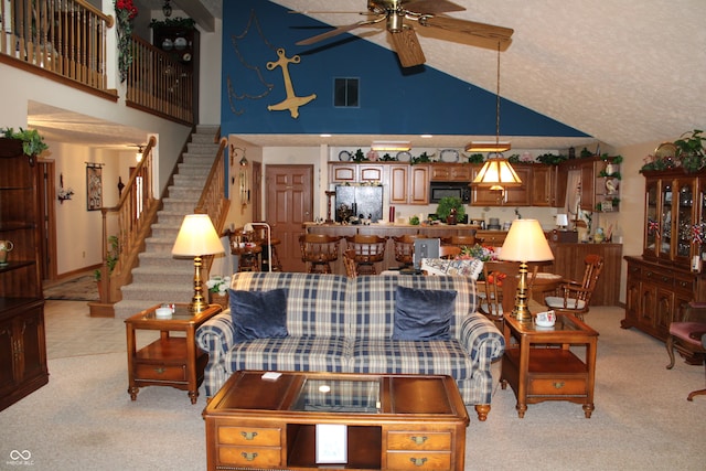 living room with visible vents, ceiling fan, stairway, light colored carpet, and high vaulted ceiling