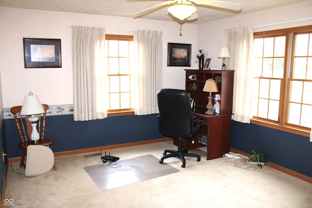 office space with visible vents, carpet flooring, a ceiling fan, and baseboards