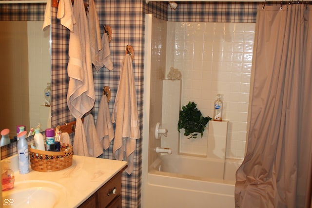 bathroom featuring wallpapered walls, vanity, and shower / tub combo with curtain