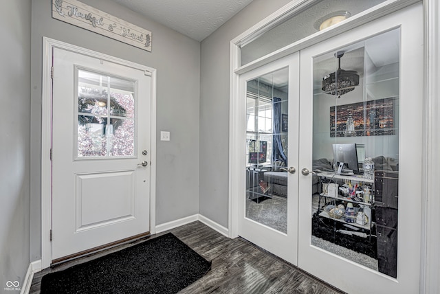 doorway to outside with a textured ceiling, plenty of natural light, dark hardwood / wood-style flooring, and french doors