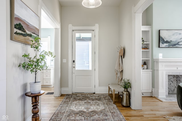 entryway featuring a fireplace and light hardwood / wood-style flooring