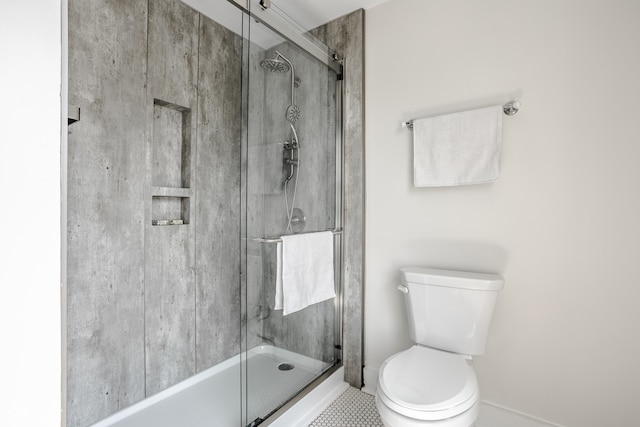 bathroom featuring toilet, an enclosed shower, and tile patterned flooring