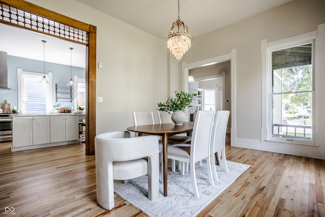 dining area with an inviting chandelier and light hardwood / wood-style floors