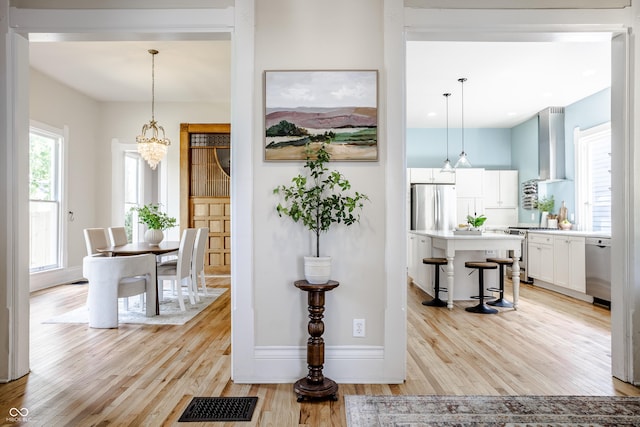 1715 Alabama St, Indianapolis, IN 46202 - hall with baseboards, a notable chandelier, visible vents, and light wood-style flooring