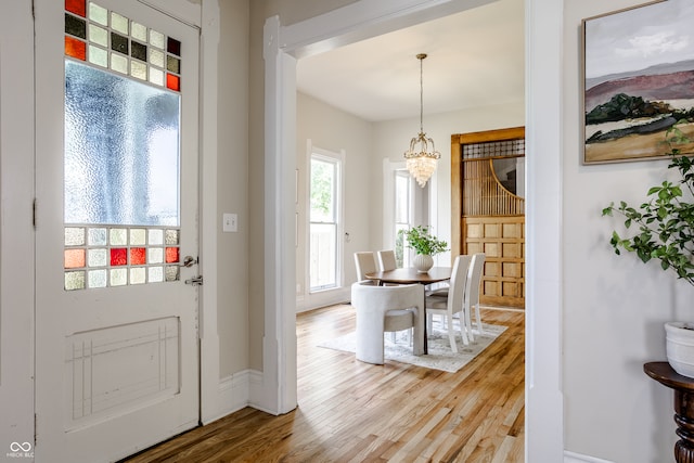 foyer entrance featuring hardwood / wood-style floors and an inviting chandelier