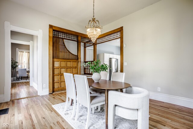 1715 Alabama St, Indianapolis, IN 46202 - dining area featuring an inviting chandelier, visible vents, light wood-type flooring, and baseboards